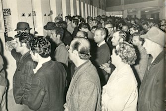 Punters queue up to place their bets at a Harold Park dog meeting. August 1969.