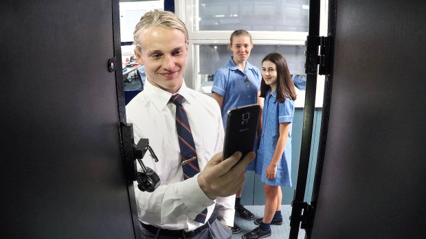 McKinnon students Xavier Verdnik (16), Catherine Braniska (14) and Louisa D'Ambra (13) have to lock their phones away in their lockers. 