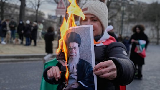 A protester burned an image of Iranian Supreme Leader Khamenei at a rally in Paris.