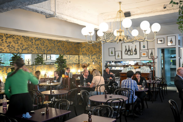 Pope Joan’s interior features a chandelier and golden wallpaper.