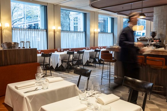 Cafe curtains, warm colours and cosy banquettes soften the room.