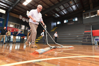 Prime Minister Scott Morrison dries a flood-damaged court in Brisbane in early March. 