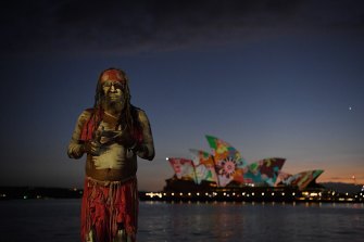 Koomurri performer Les Daniels in front of the projection of artwork by Pitjanjara artist Yadjidta David Miller on the sails of the Opera House on Australia Day. 