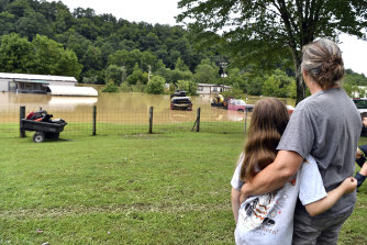 Bonnie Combs, right, hugs her 10-year-old granddaughter Adelynn Bowling watches as her property becomes covered by the North Fork of the Kentucky River.