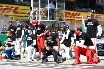 Drivers take a knee on the grid in support of the Black Lives Matter movement.