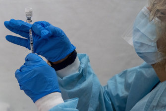 A pharmacist fills a dead volume syringe with the Pfizer-BioNTech COVID-19 vaccine.