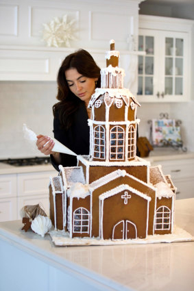 Ginger bread house architect Rebecca Lauren with one of her $2500 Christmas creations.