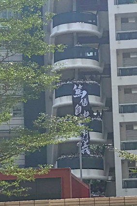 Ying Wa primary school students unfurl a banner and chant next to the West Kowloon court.