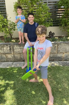 Ryan Batchelor and sons Clement, 3, and Lewis, 7, playing backyard cricket.