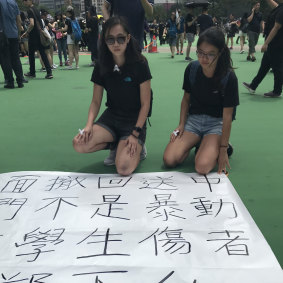 Kim, left, with her poster depicting the last words of a young protester who fell to his death in the Hong Kong protests. 