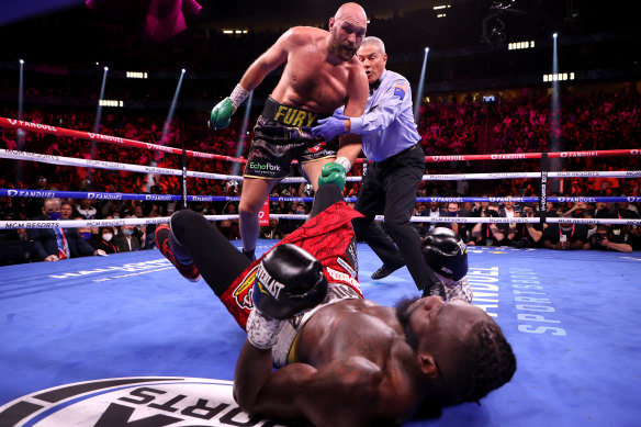 Fury stands over Wilder after a third-round knockdown.