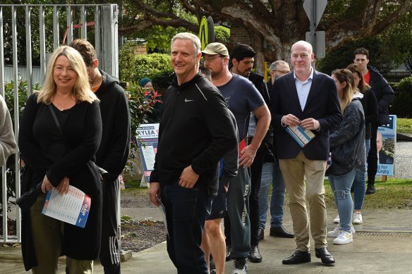 Liberal candidate Trent Zimmerman (3rd from right) waits in line to cast his vote in the North Sydney electorate at the Willoughby Public School School on Saturday.