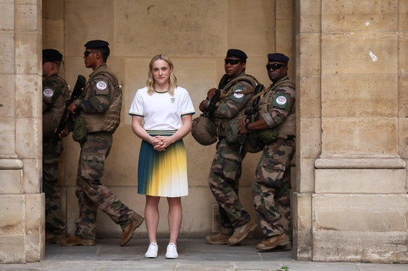 Australian gymnast Emily Whitehead poses for a photographer as armed security personnel walk by in Paris.