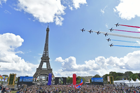 The elite aerial acrobatic team, Patrouille de France, perform behind the Eiffel Tower in Paris on Sunday to celebrate the handover of the Olympic flag to the city that will host the 2024 Games.
