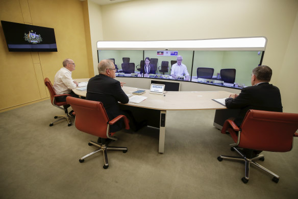 Secretary of the Department of Prime Minister and Cabinet Phil Gaetjens, Prime Minister Scott Morrison and Chief Medical Officer Professor Brendan Murphy speak with NSW Premier Gladys Berejiklian and Secretary of Department of Premier and Cabinet Tim Reardon
(on screen).