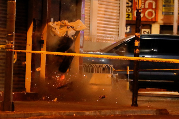 Police undertake a controlled explosion of a device left outside the rally attended by presidential candidate Fernando Villavicencio in Quito.