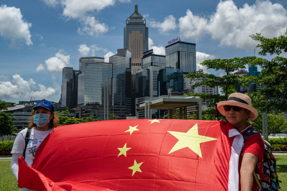 Pro-Beijing supporters in Hong Kong wave a Chinese flag and sing the national anthem in celebration of the passing of the new national security law on Tuesday.