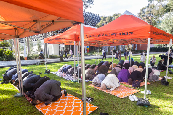 Islamic students pray outdoors in protest at inadequate prayer facilities at Monash University.