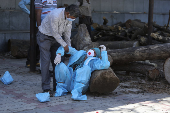 A relative of a person who died of COVID-19 breaks down during cremation in Jammu, India.