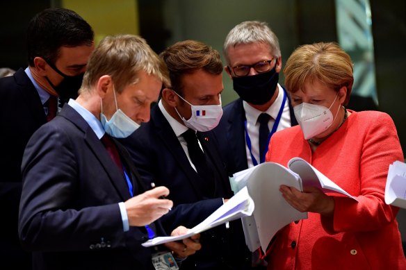 Leaders, among them German Chancellor Angela Merkel, right, and French President Emmanuel Macron, centre, worked out the deal over several marathon sessions in Brussels.