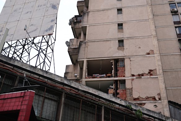 The interior of an apartment lies partly exposed by a building collapse.