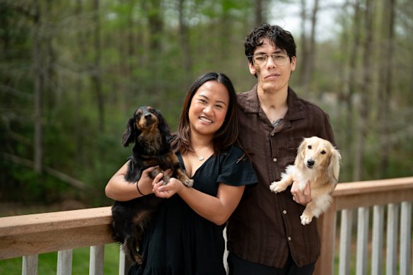 Jasmine Policarpio and Travis Reyes at home in Maryland with their pet dogs.