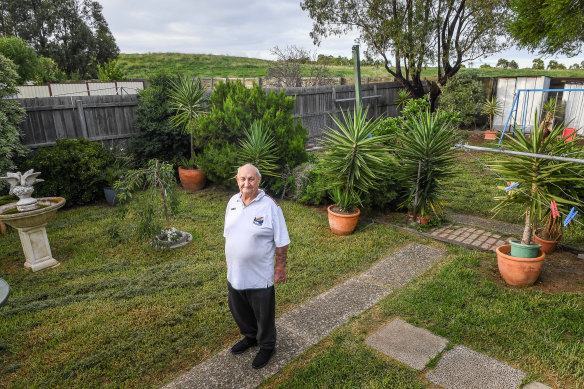 William Cartledge in his backyard, with the hill which was built on top of the Sunshine Landfills tip behind him.