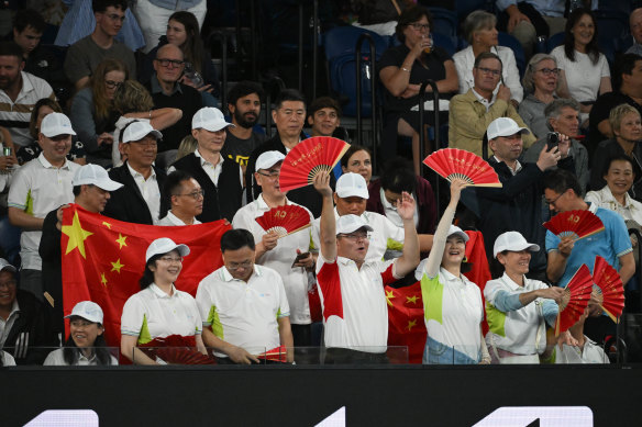 Chinese fans cheer on Qinwen Zheng from courtside seats.