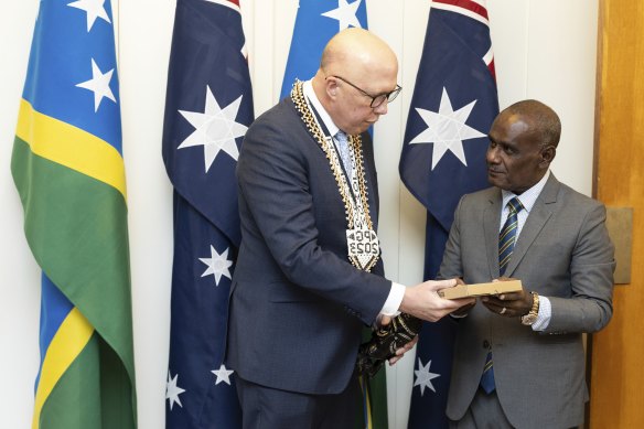 Opposition Leader Peter Dutton and Jeremiah Manele exchange gifts at Parliament House.