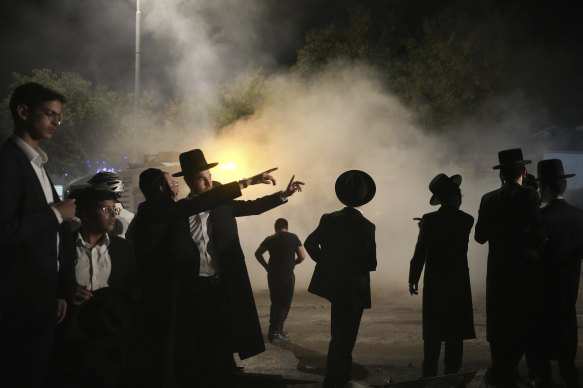 Ultra-Orthodox Jewish men inspect a road after it was hit by a rocket fired from the Gaza Strip, in the West Bank settlement of Beitar Illit this week.