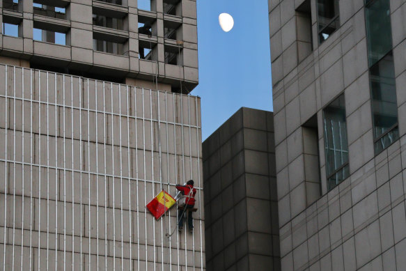 A migrant worker abseils down a building in Beijing. 
