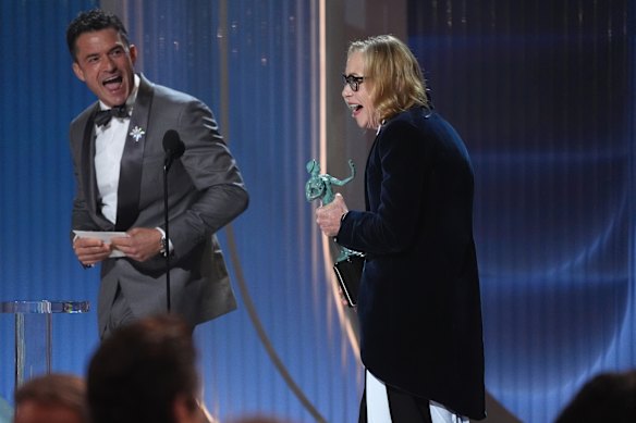 Orlando Bloom, left, presents the award for outstanding performance by a female actor in a supporting role to Amy Madigan for Weapons.