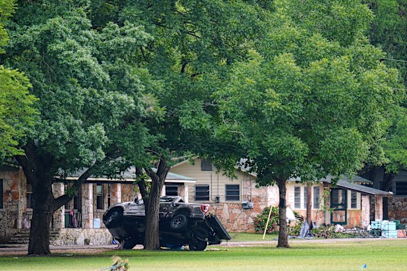 Un camión descansa sobre un árbol afuera de los dormitorios en Camp Mystic.