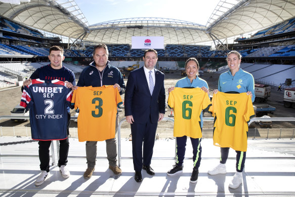 From left: Roosters forward Victor Radley, Wallabies coach Dave Rennie, NSW Minister for Sport Stuart Ayres and Matildas Kyah Simon and Alanna Kennedy. The jerseys have the date of their respective teams’ games in September at the new Allianz Stadium.