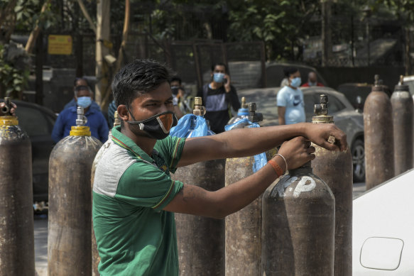 Family members of COVID-19 patients wait to refill their oxygen cylinders in New Delhi, India.