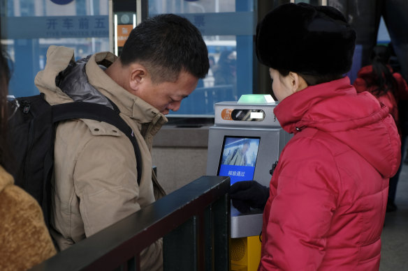 Facial recognition is widely used in  China, like here, where Beijing commuters have their face scanned at the railway station. 