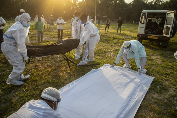Municipal workers prepare to bury the body of a person who died of COVID-19 in Gauhati, India this week.