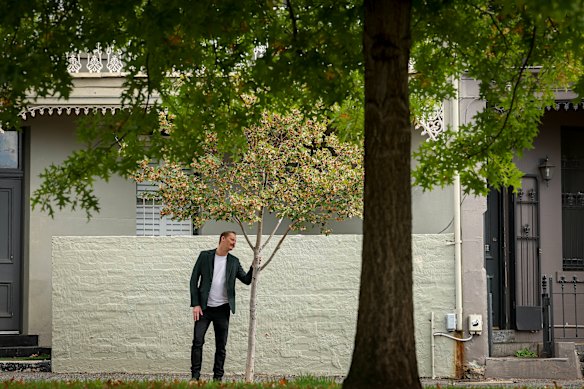 Thami Croeser demonstrates how the street trees on Canning Street in Carlton in Melbourne’s inner north are failing to thrive, compared with the established trees in Carlton Gardens.
