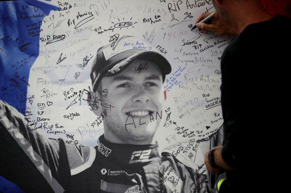 A man signs a remembrance board for Formula 2 driver Anthoine Hubert at the Belgian Grand Prix.