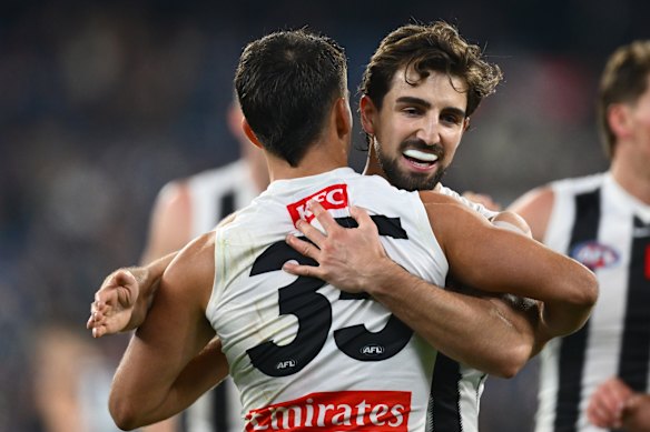 Nick Daicos hugs his brother Josh, right, in the clash against Carlton.