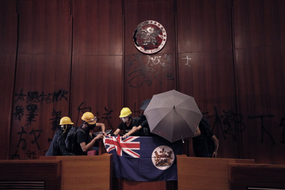 Protesters with a colonial-era flag storm Hong Kong's Legislative Council on July 1.