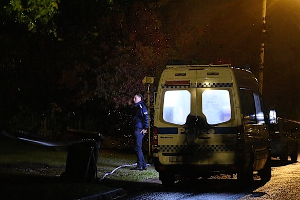 A police officer stands at the crime scene near where the bodies of two children and a woman were found inside a home in Campbelltown. 
