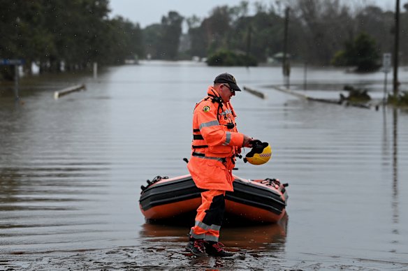 An SES member at a staging point on Manning River Drive, Purfleet, where rescue boats have been launched.