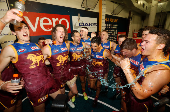 Matt Eagles, second from the left, celebrates with teammates after the Lions beat Hawthorn in 2018.  
