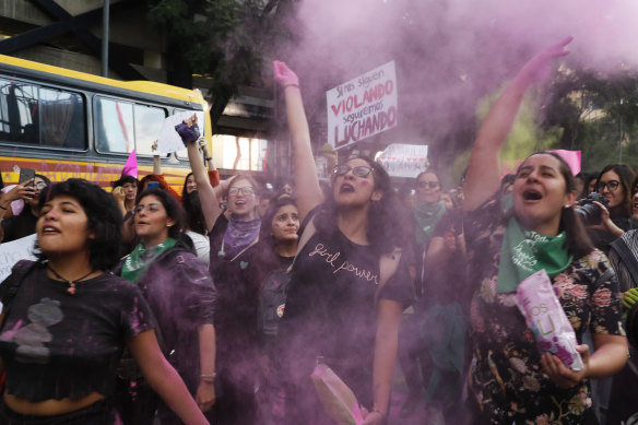 Women toss pink glitter during a protest march demanding justice and for their safety, sparked by two recent alleged rapes by police, in Mexico City.