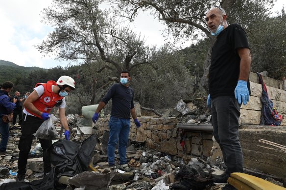 Villagers and the Red Cross sift through the rubble of a house flattened by an Israeli air strike in Aitou, Lebanon.