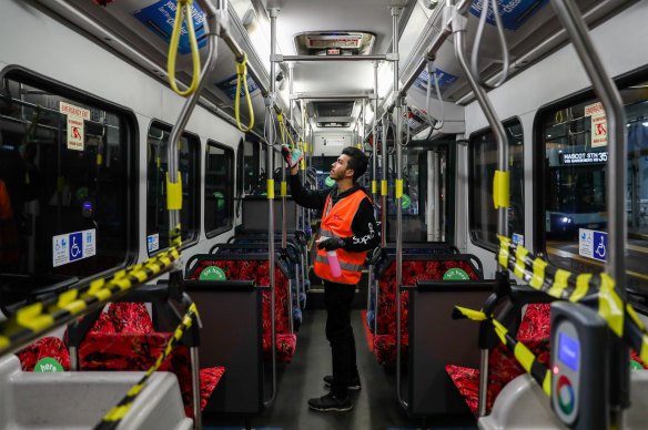 A cleaner disinfects a Sydney bus amid strict social distancing measures placed on the network.