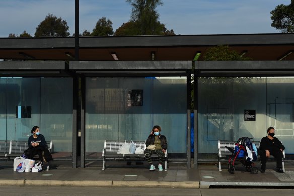 People wait for buses at Fairfield during Sydney’s COVID-19 lockdown. 