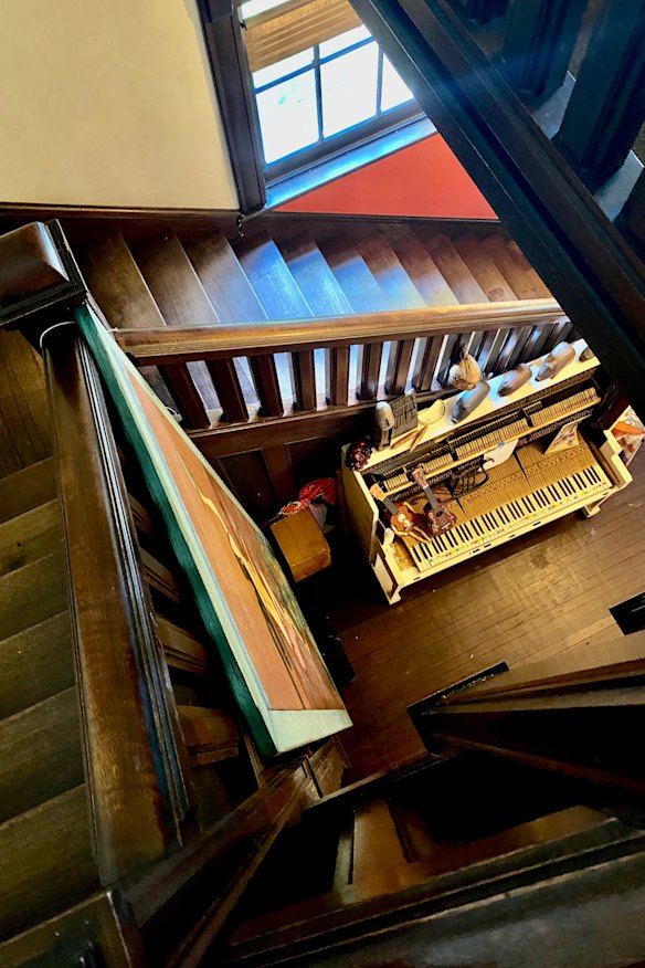 A Hogwart's style central staircase winds down to a heavily decorated surrealist piano.