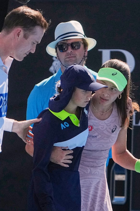 Sonmez and umpire Chase Urban help a ball kid who fainted.